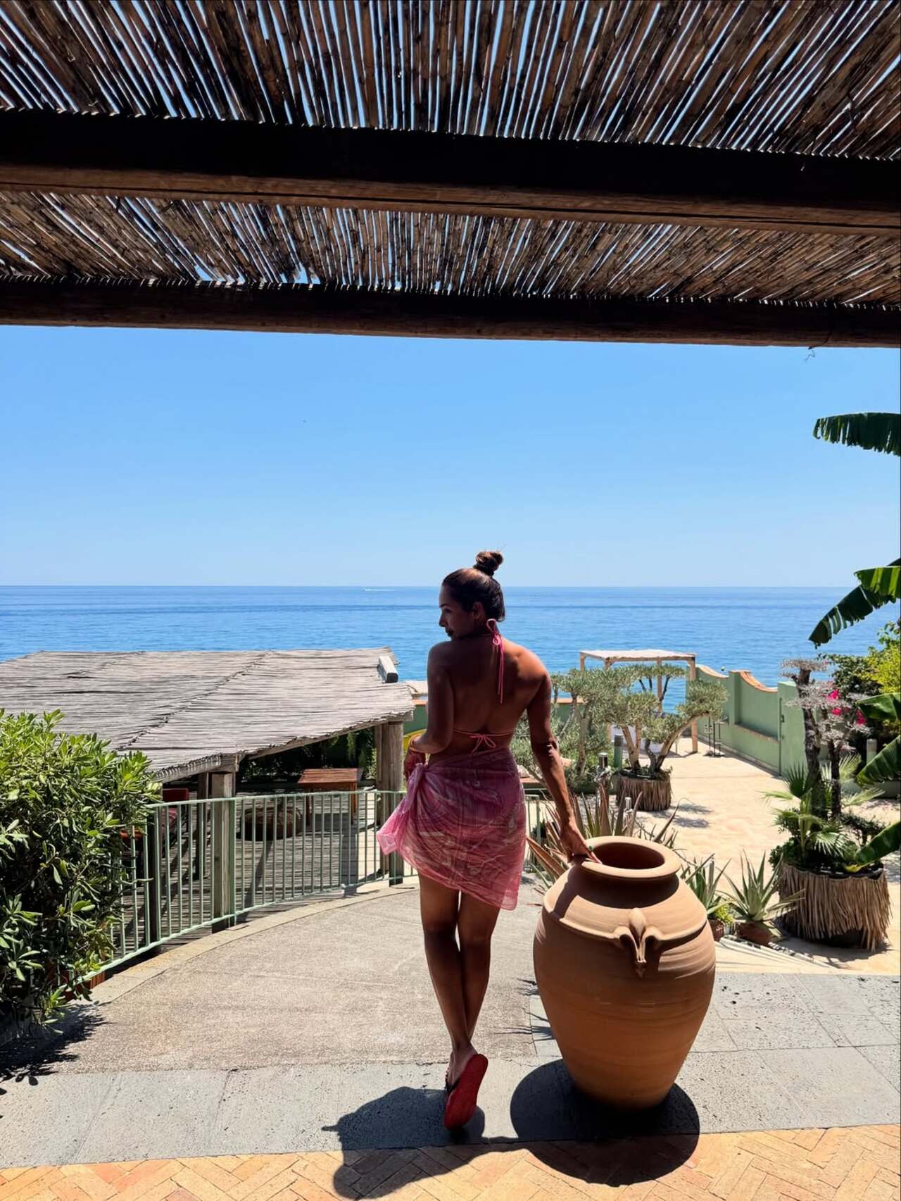 Malaika accessorized her stylish poolside attire with a sloppy top knot to create a laid-back atmosphere